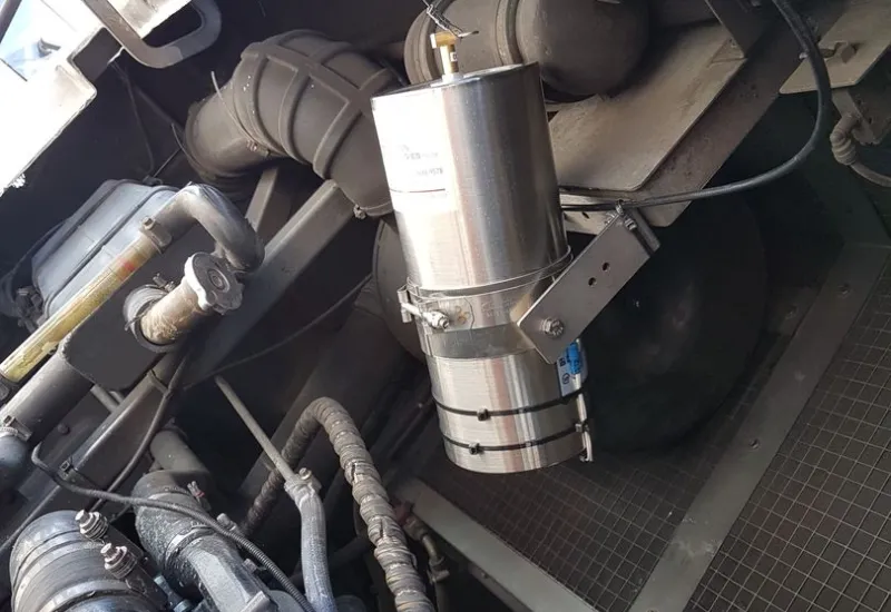 Close-up of engine components and metal piping inside a vessel’s machinery area.